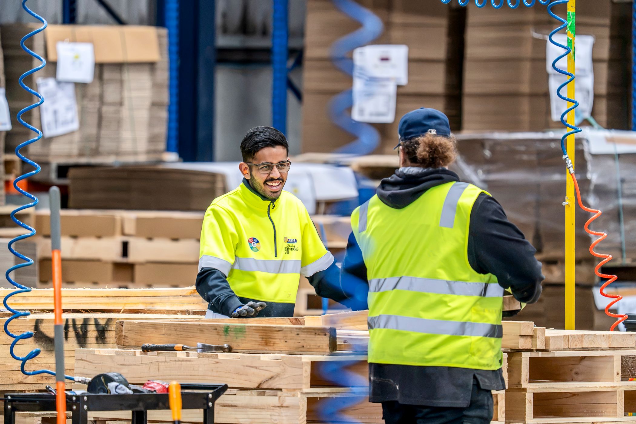 Smiling CMTP factory worker building HACCP International certified food-grade pallets