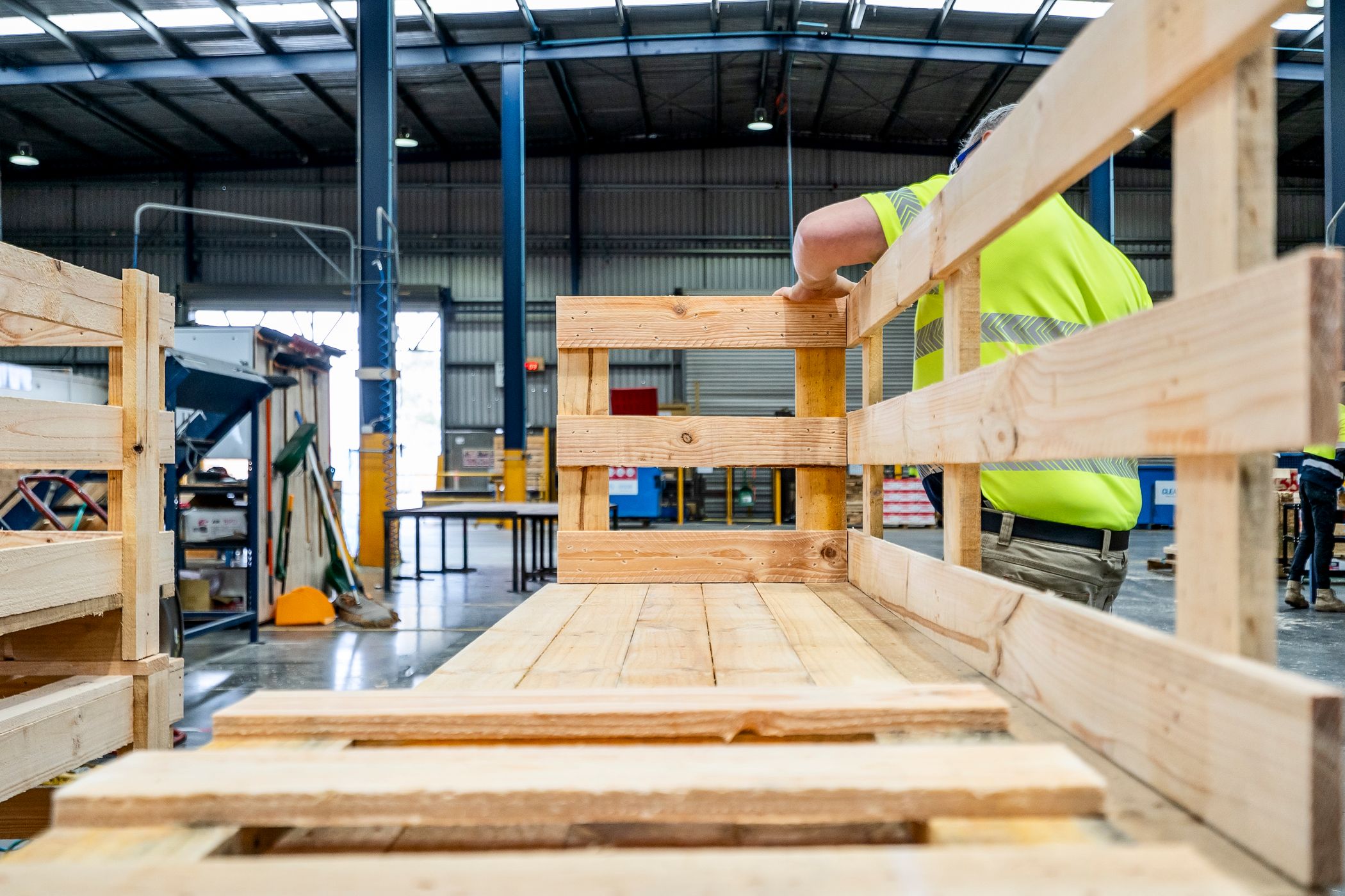 CMTP team member building a custom wooden crate by hand on the production floor