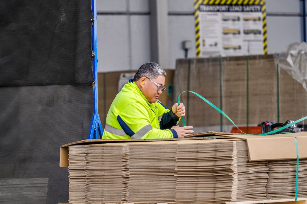 A CMTP worker strapping down a large stack of custom-made cardboard boxes at the Dandenong South site in Melbourne